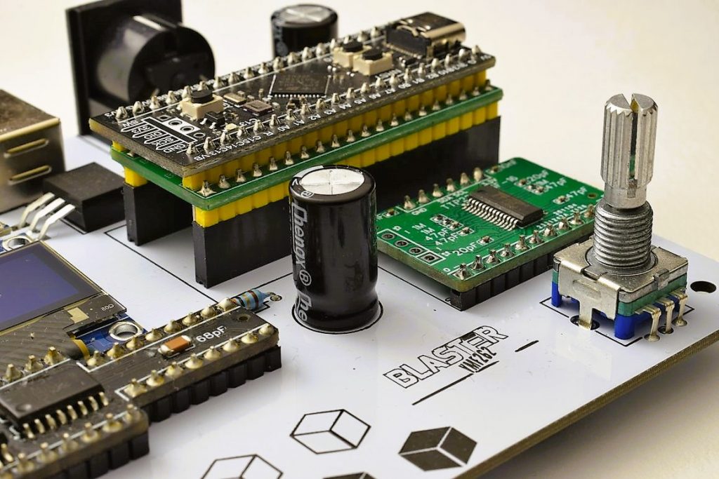 Close-up of the white DAFM Blaster YMF262 circuit board with a green microcontroller module and a rotary encoder