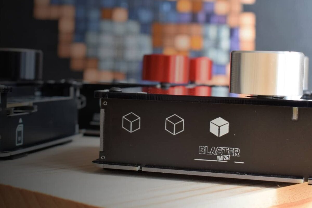 DAFM Blaster YMF262 synth by Kasser Synths on a wooden table, with other handmade DAFM synths behind it