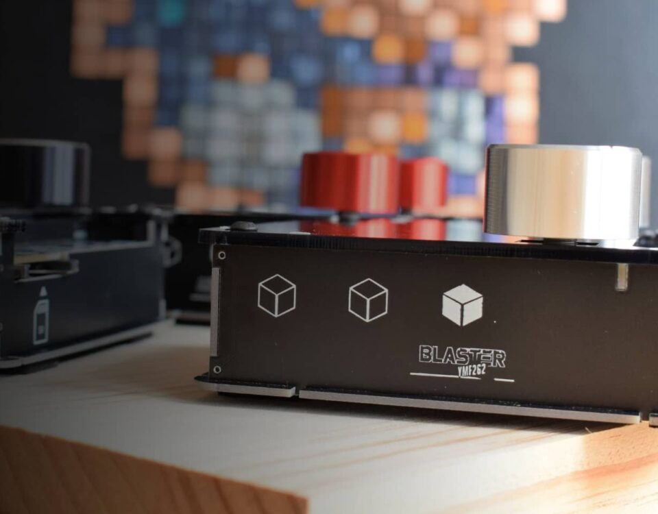DAFM Blaster YMF262 synth by Kasser Synths on a wooden table, with other handmade DAFM synths behind it
